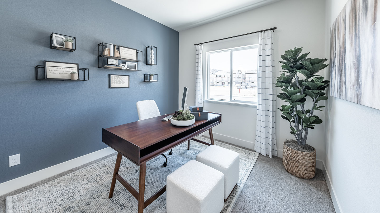 Office on first floor of the home with carpeted floor and a large window