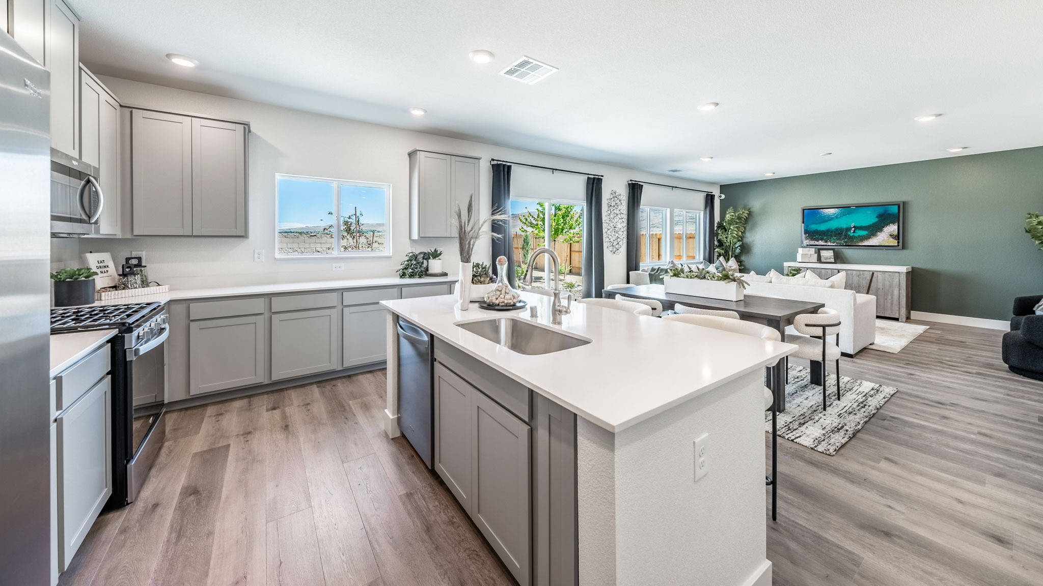 Bright modern kitchen with island, large pantry and window above the sink