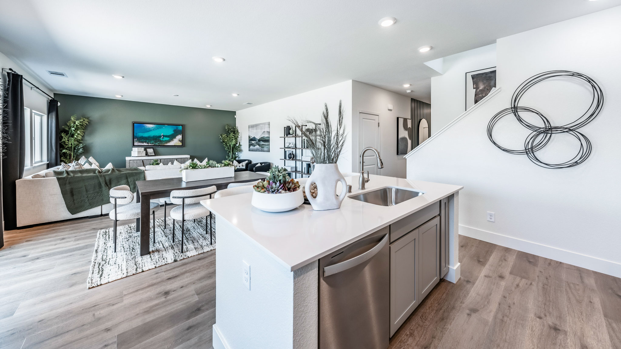 Kitchen island with built-in sink and dishwasher looking out onto dining and living area