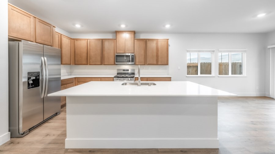 Kitchen with an island, white shaker-style cabinets and stainless steel appliances
