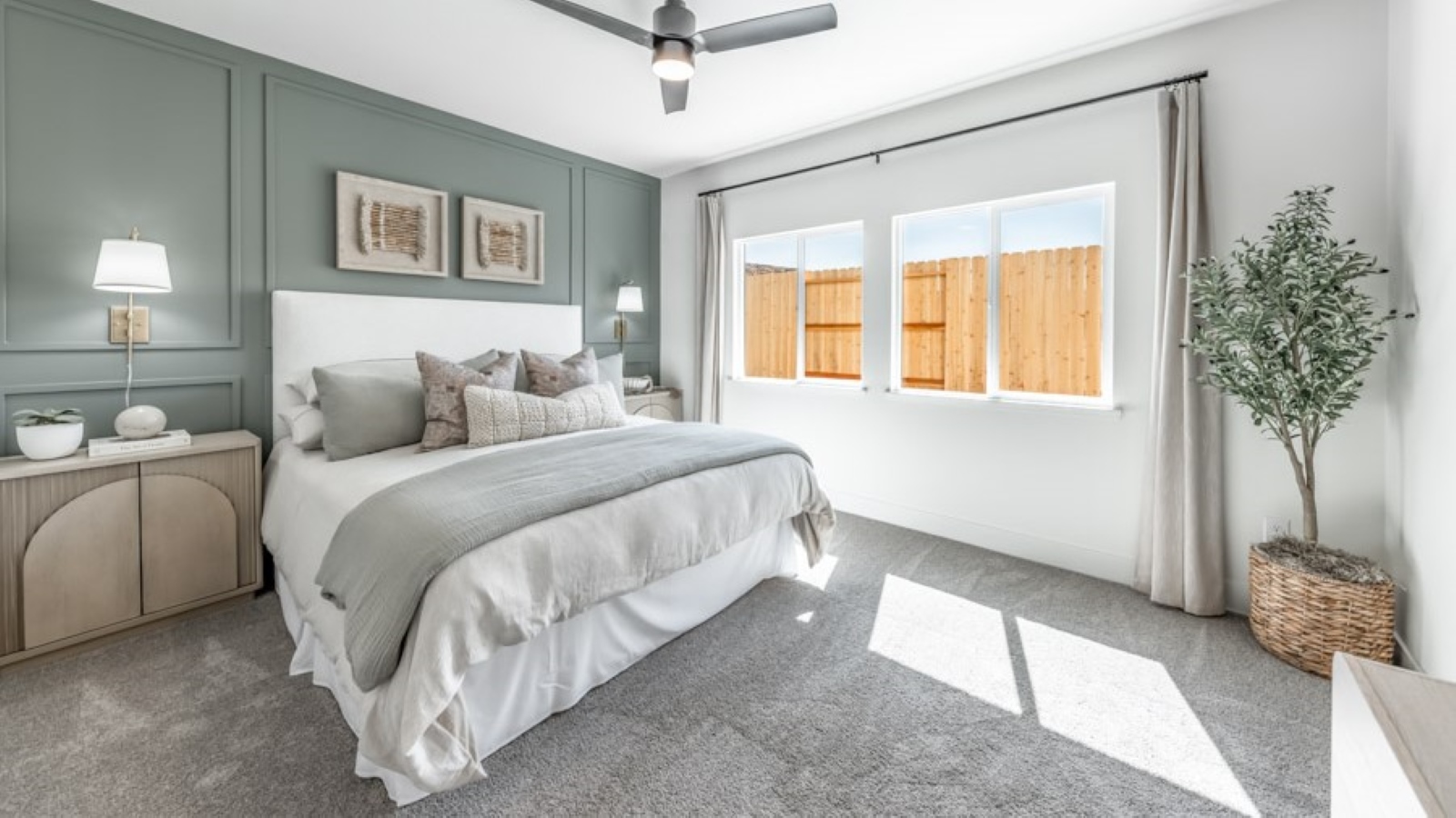 Carpeted primary bedroom with large windows and attached bathroom