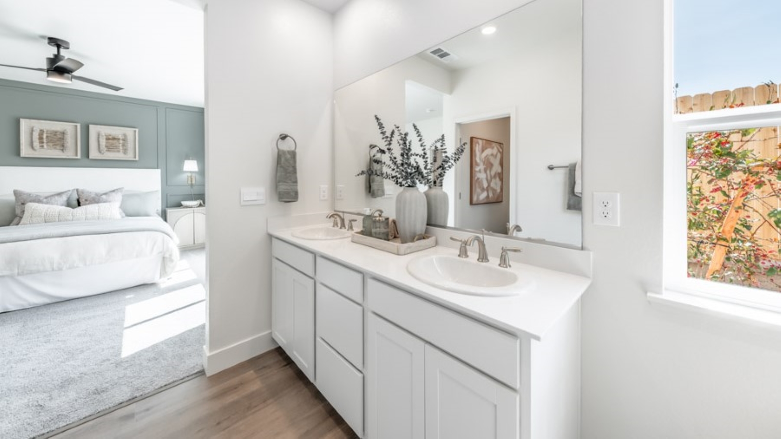 Primary bathroom double vanity next to small window