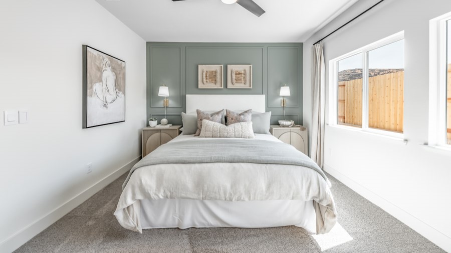 Carpeted primary bedroom with two large windows