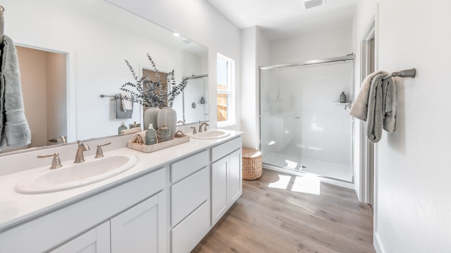 Primary bathroom double vanity next to small window