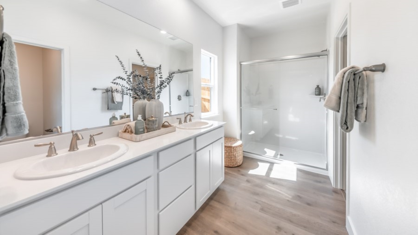 Primary bathroom double vanity next to small window