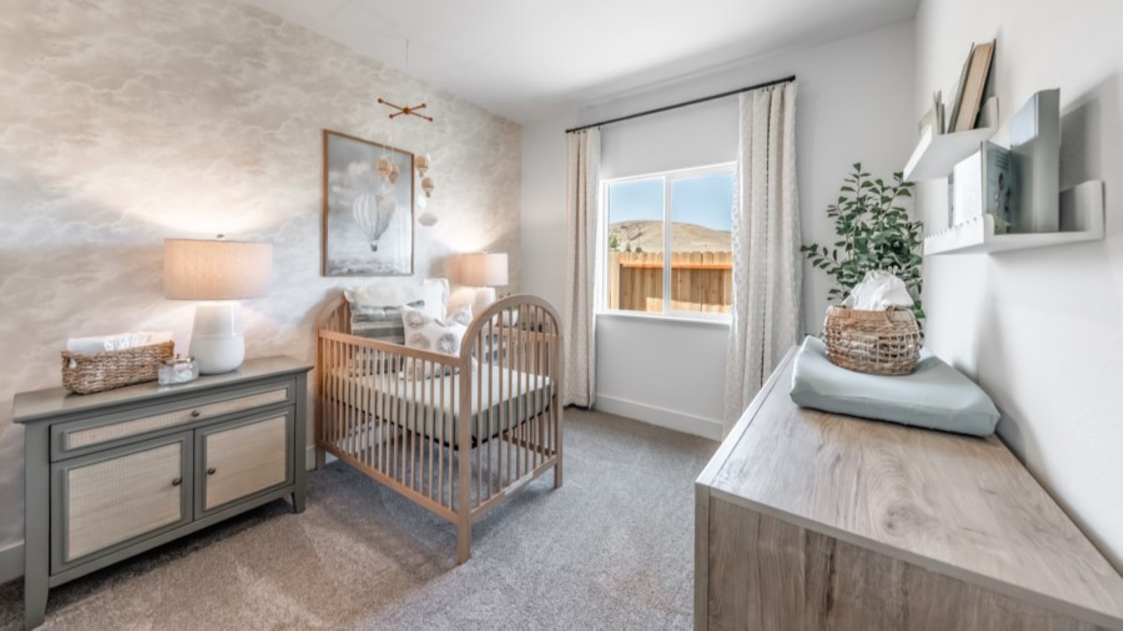 Secondary bedroom decorated as a nursery with carpeted floors