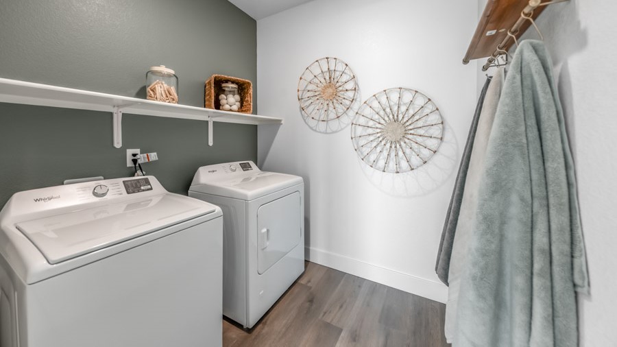 Laundry room with shelf above full-sized washer and dryer