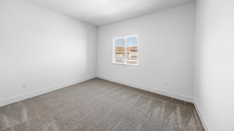 Bedroom on the first floor on the home with large window letting in natural light