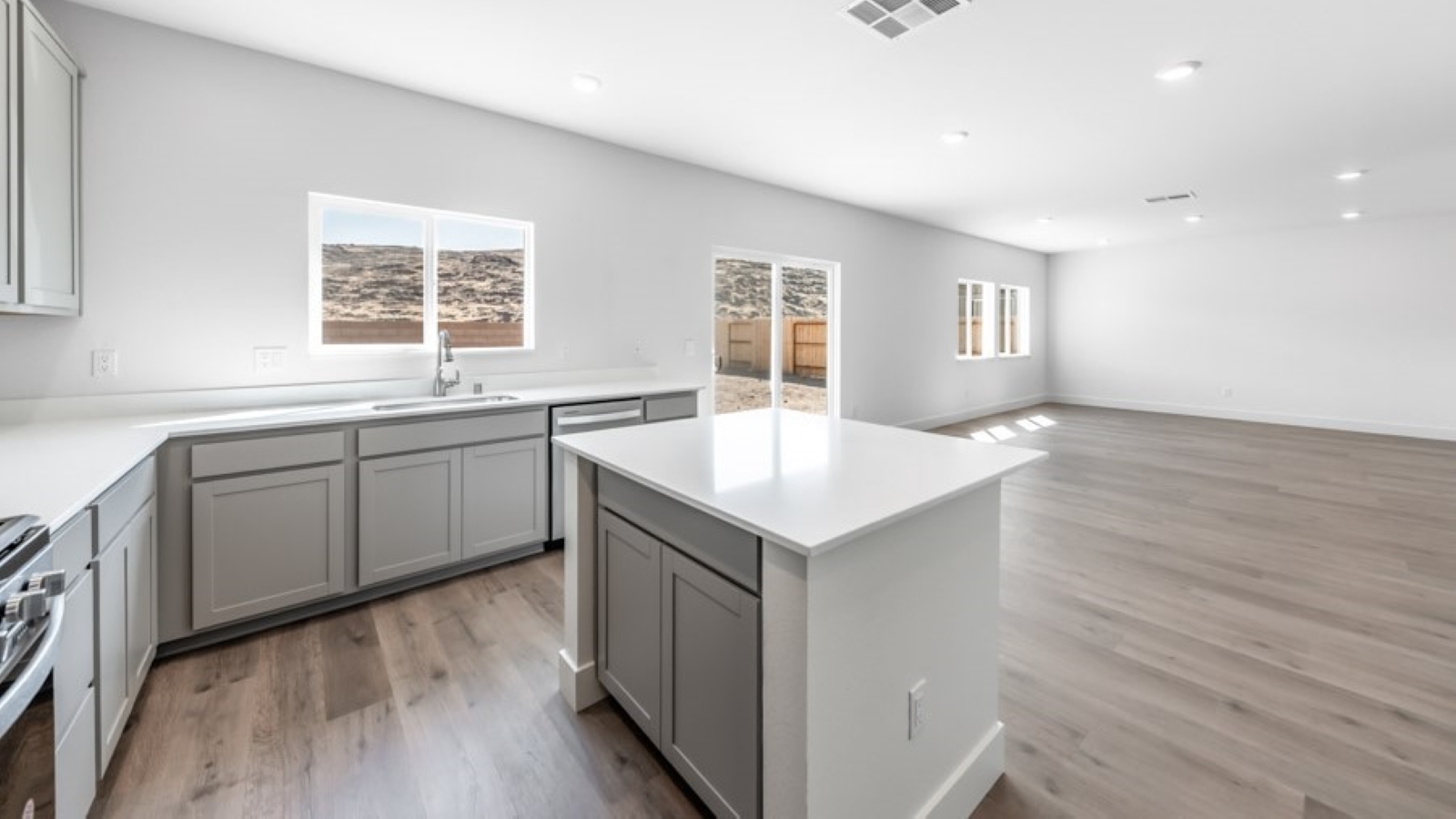 Kitchen island with built-in sink and dishwasher looking out onto dining and living area