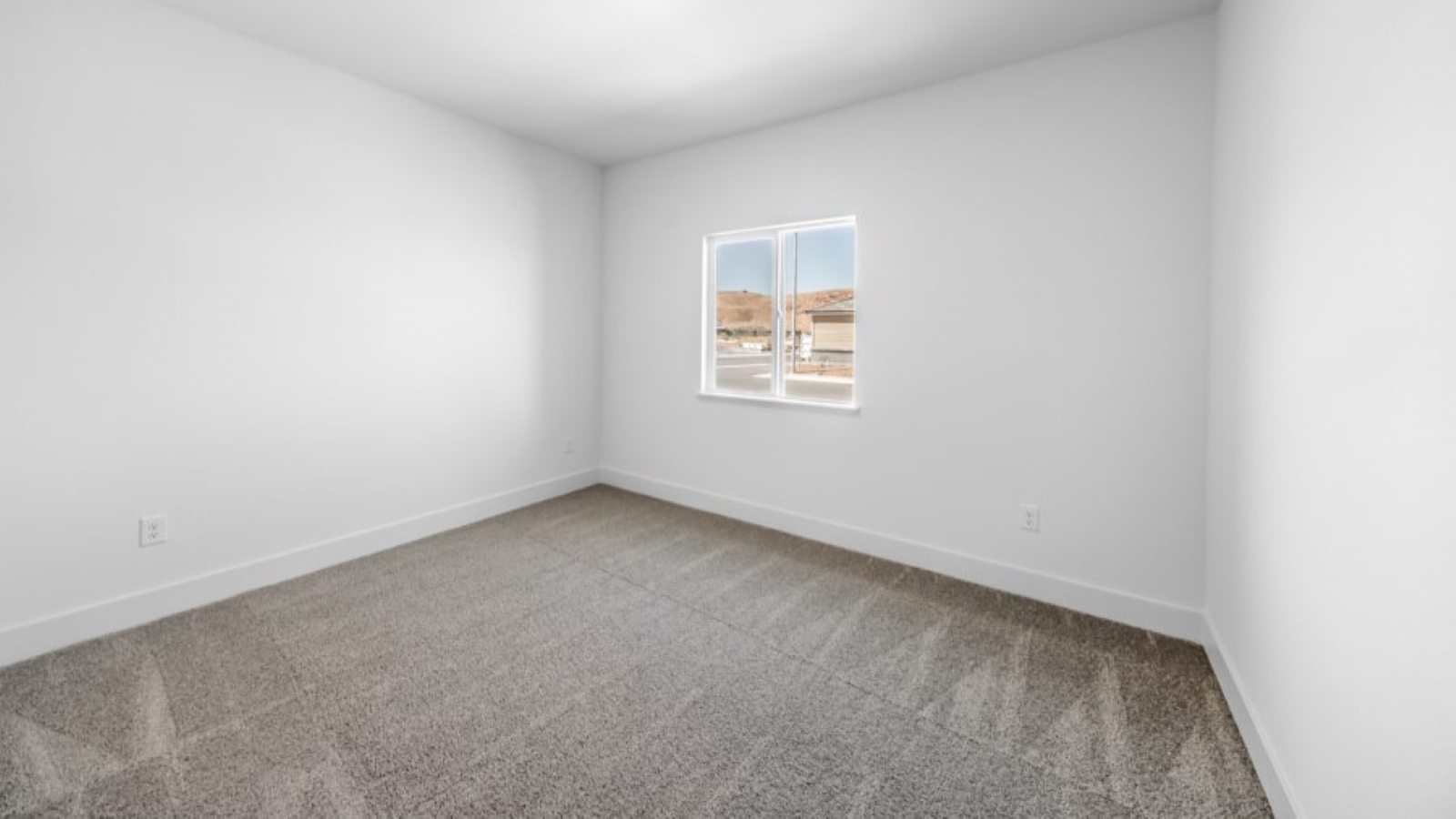 Bedroom on the first floor on the home with large window letting in natural light