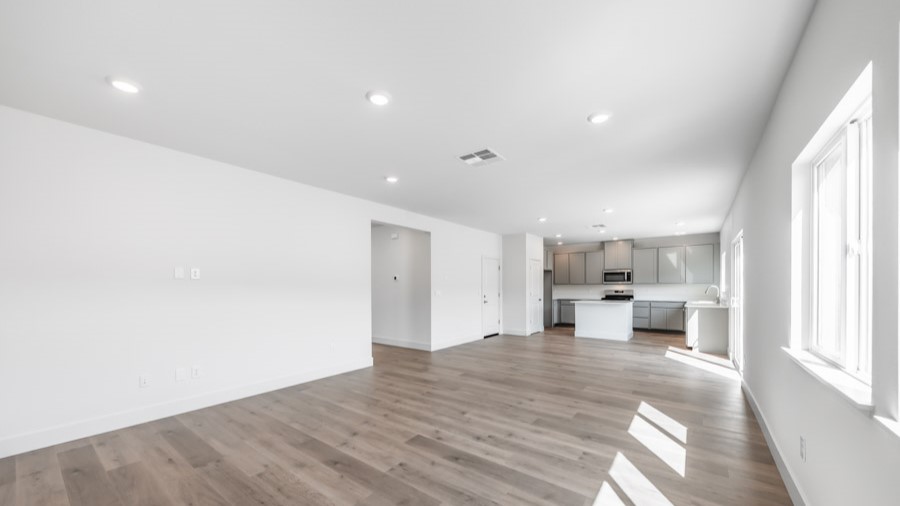 Living room with space for a large sectional couch and large bright windows