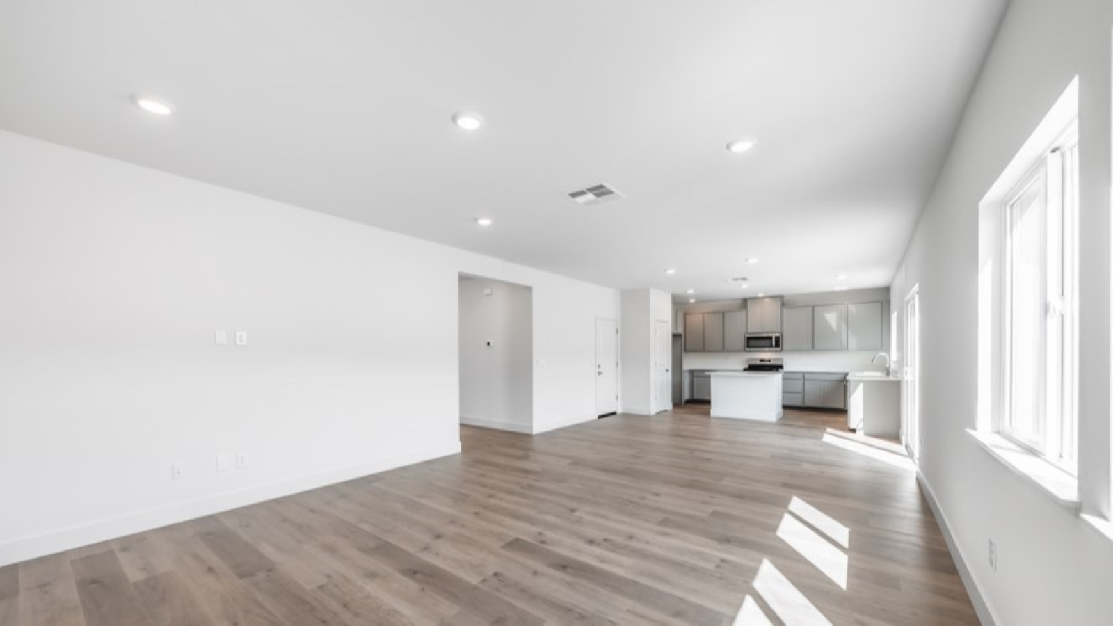 Living room with space for a large sectional couch and large bright windows