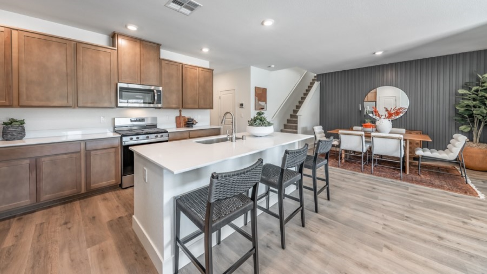 Large kitchen island with space for three barstools separating kitchen area from the rest of the open-concept first floor