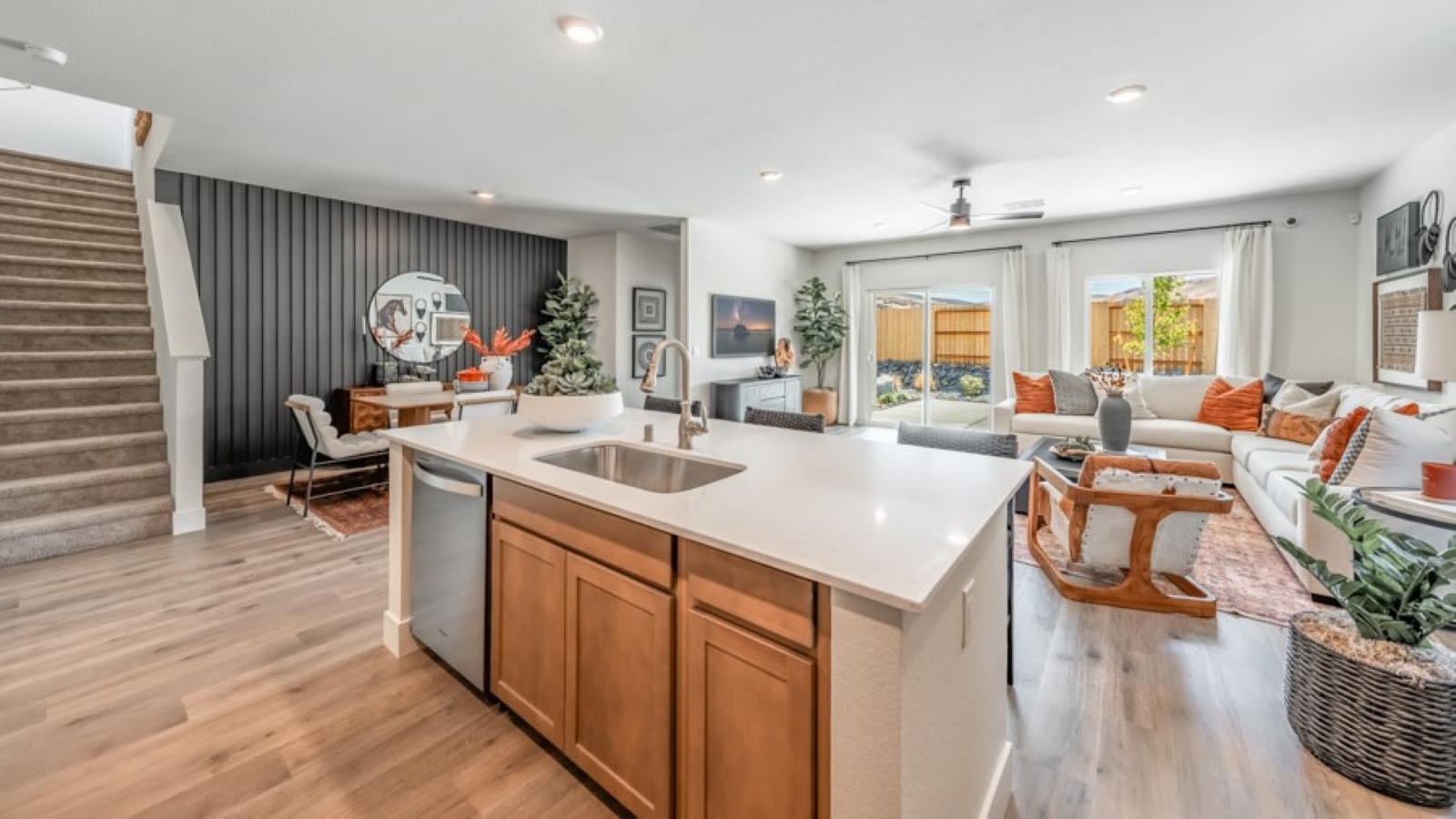 Kitchen island with built-in sink and dishwasher looking out onto dining and living area