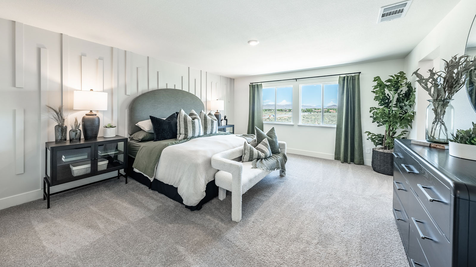 Large primary bedroom with large windows and carpet