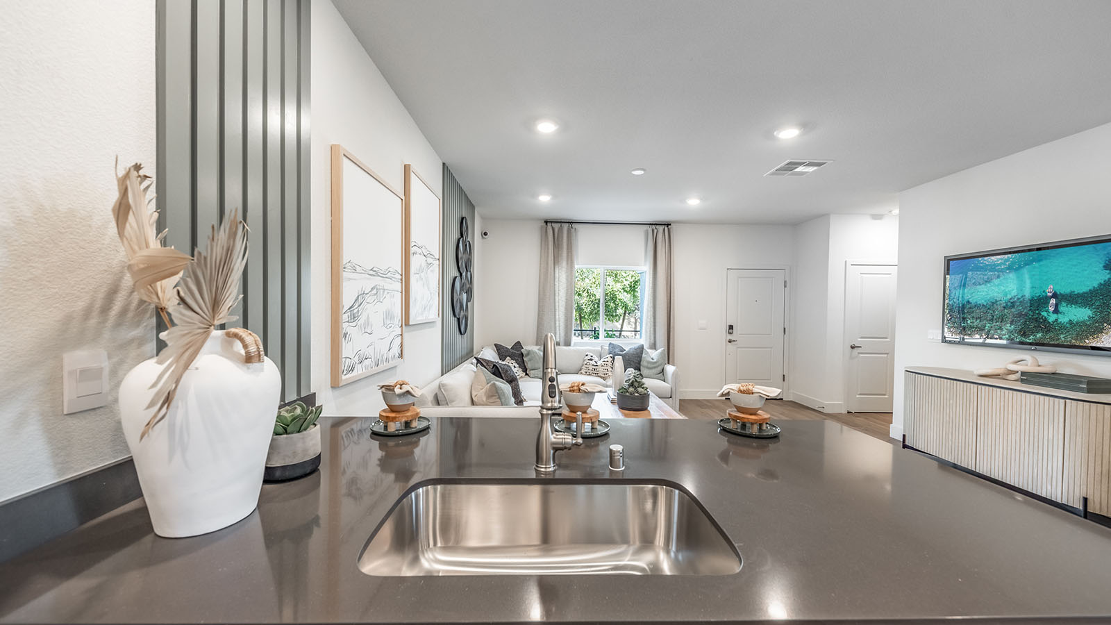 Kitchen island with sink basin looking into the great room