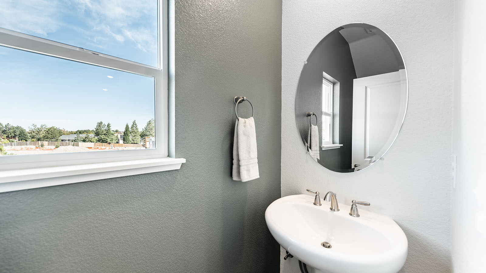 Second half-bathroom with small sink and a large window on first floor