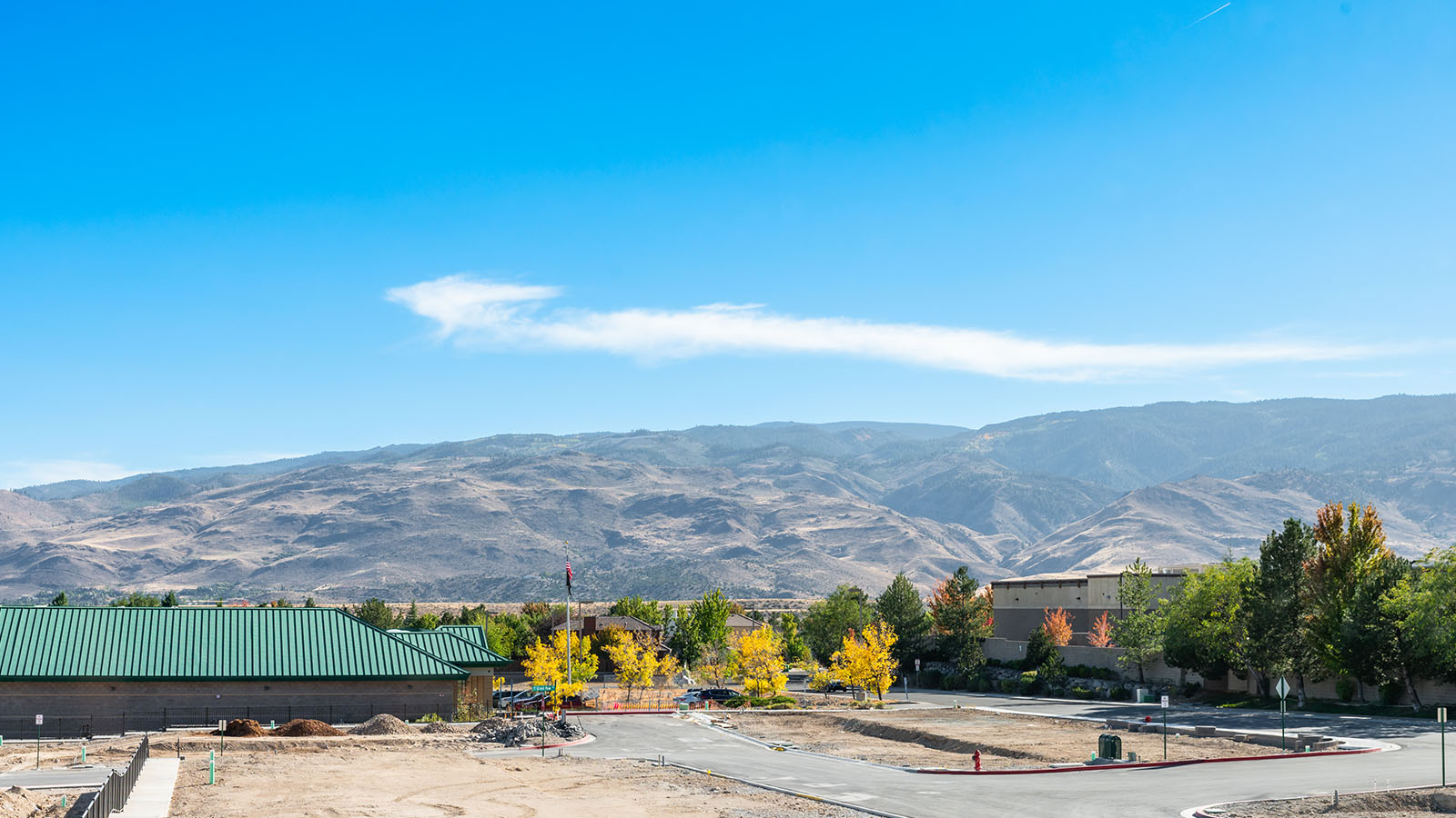View from second floor window that shows mountains, Raley's store and trees
