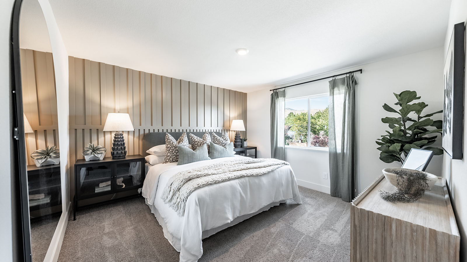 Large primary bedroom with carpeted floor and large windows