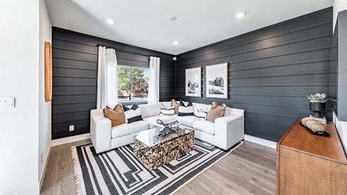 Modern living room with black accent wall and large window