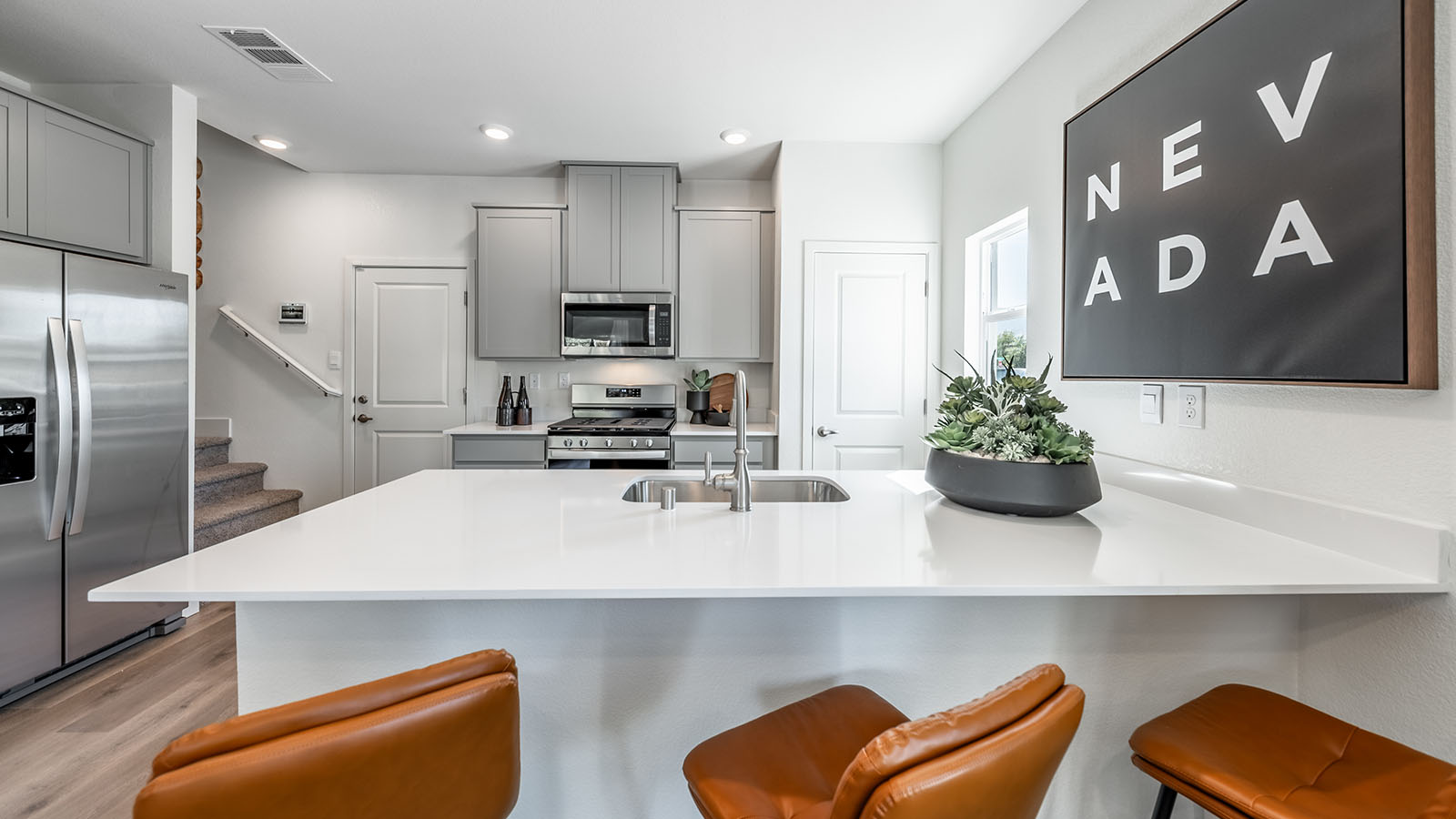 Kitchen peninsula with barstools looking into kitchen with pantry