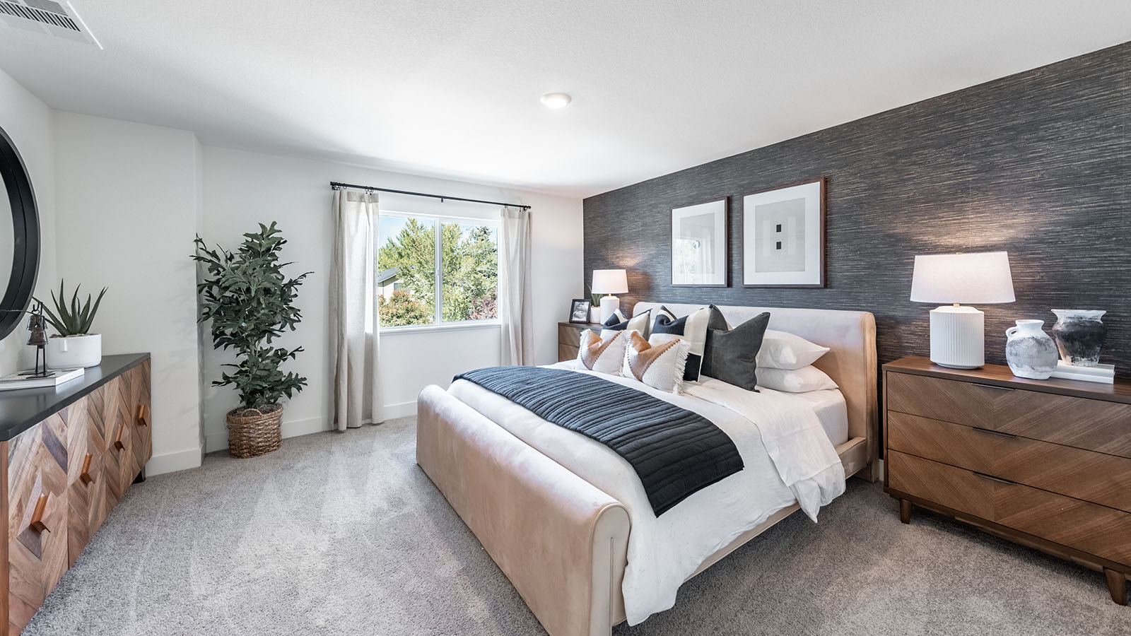 Large carpeted primary bedroom with accent wall and large window