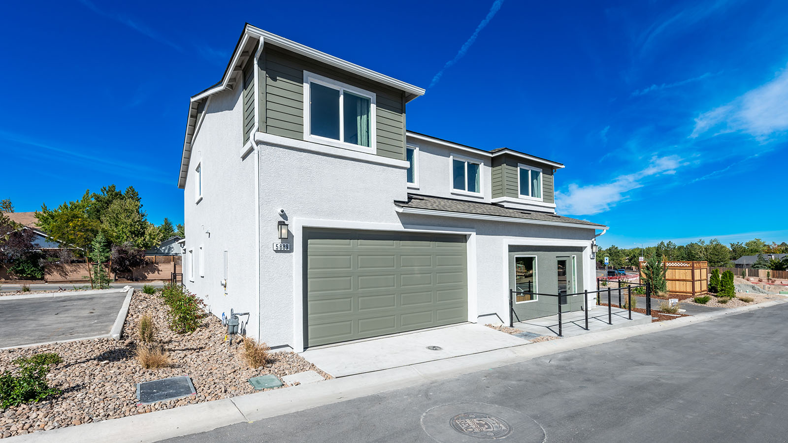 Two-car garage entry at the back of the home with green door