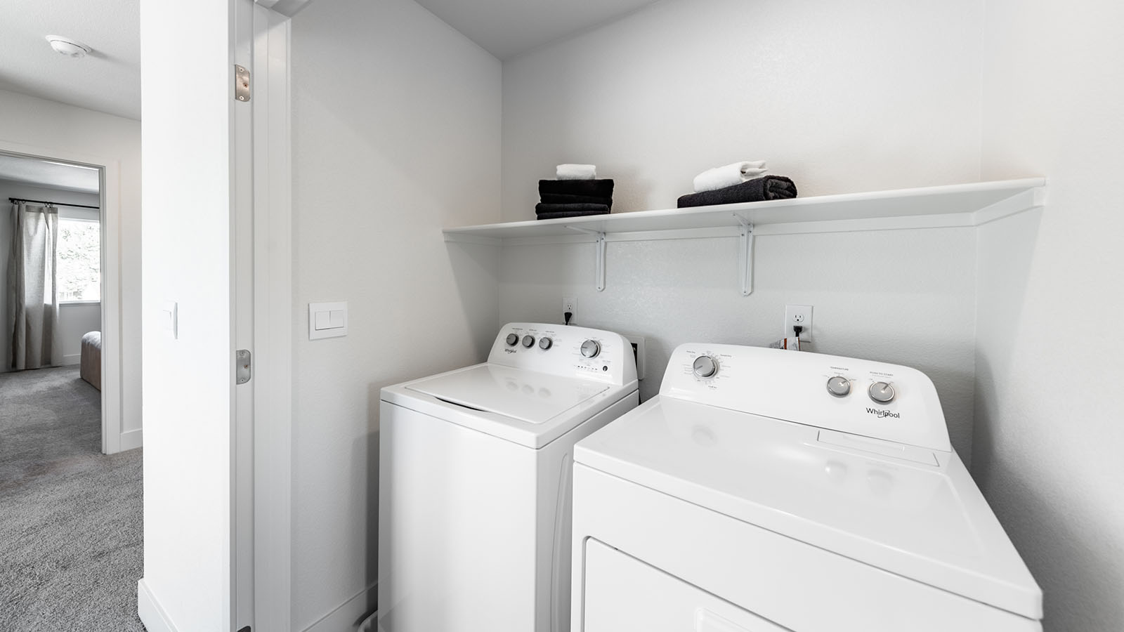 Separate laundry area with room for washer and dryer with a shelf built above