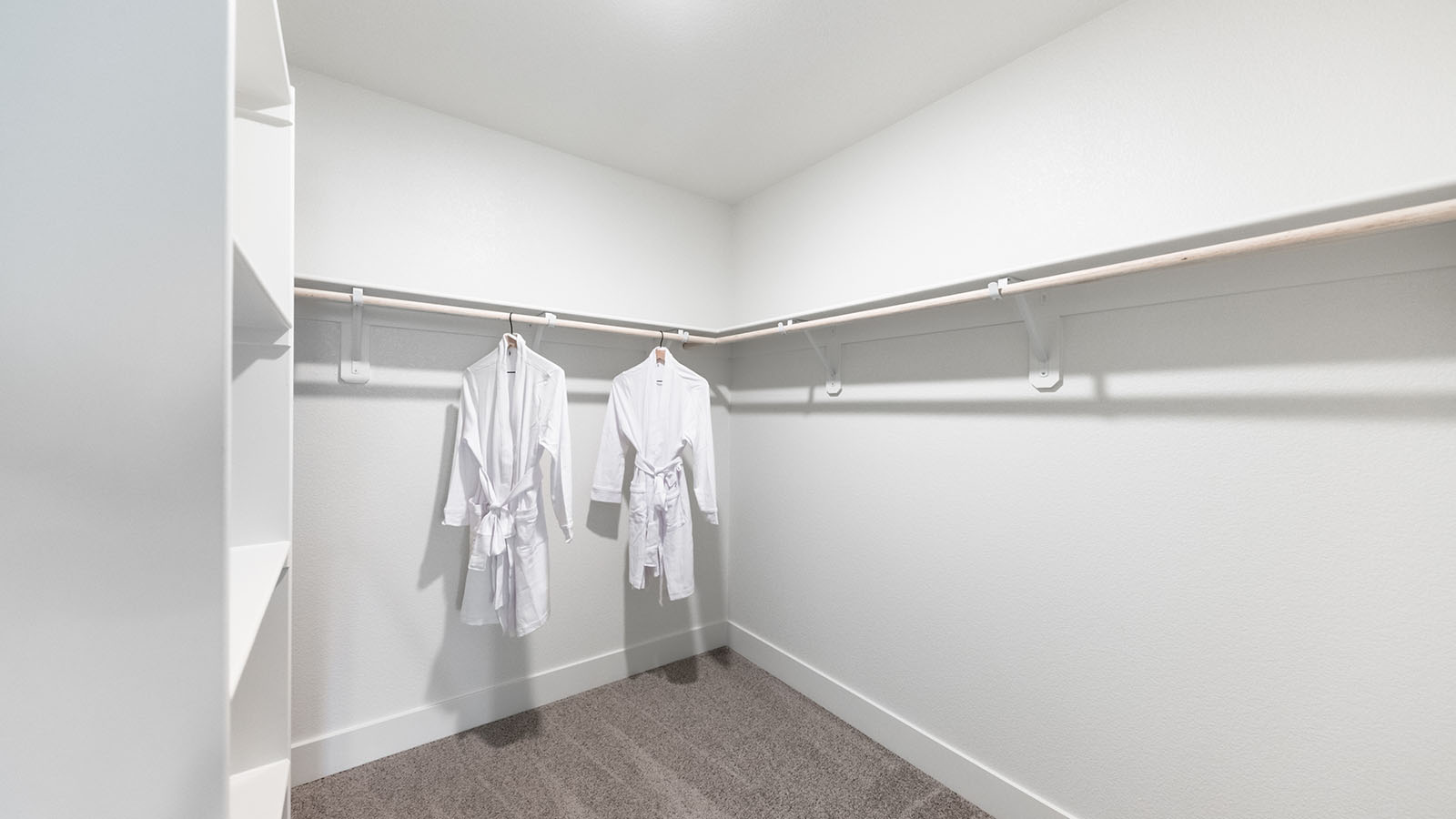 Large walk-in carpeted closet with built-in shelf