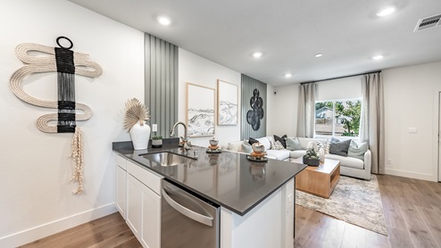 Kitchen island looking onto living area with large windows in the Walker floorplan