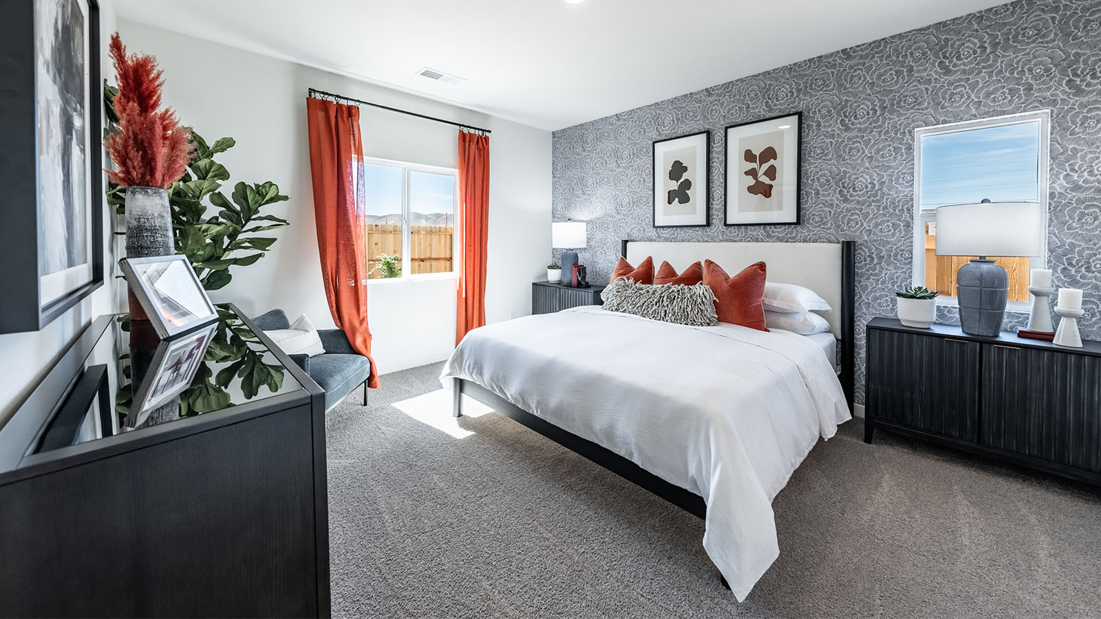 Primary bedroom with carpeted floors and two large windows for bright light