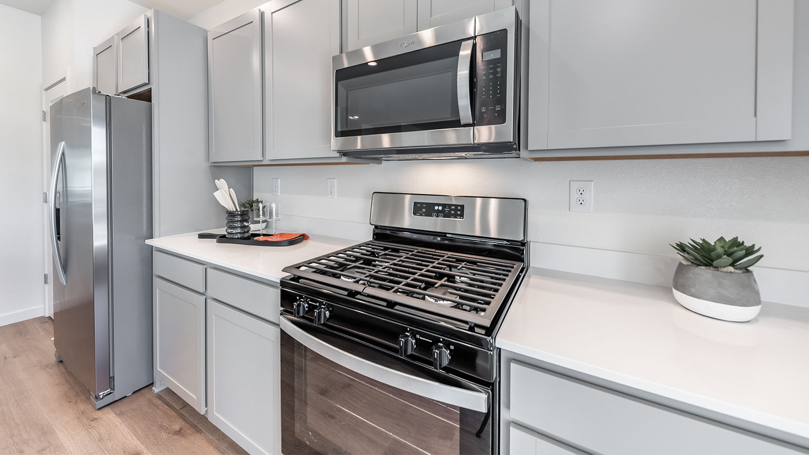 Stainless steel stove, microwave and refrigerator in modern kitchen