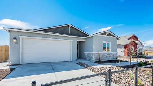 Model home exterior with two-car garage and stucco and stone finishes