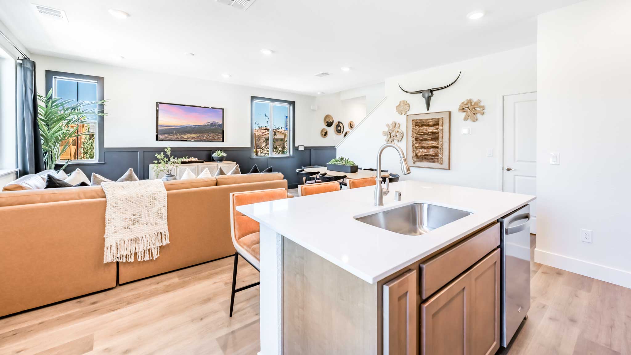 Kitchen island with single basin sink and dishwasher looking out towards the great room