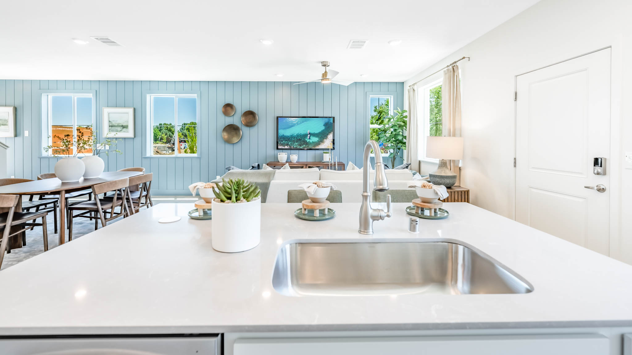 Kitchen island with a single basin sink looking towards the great room