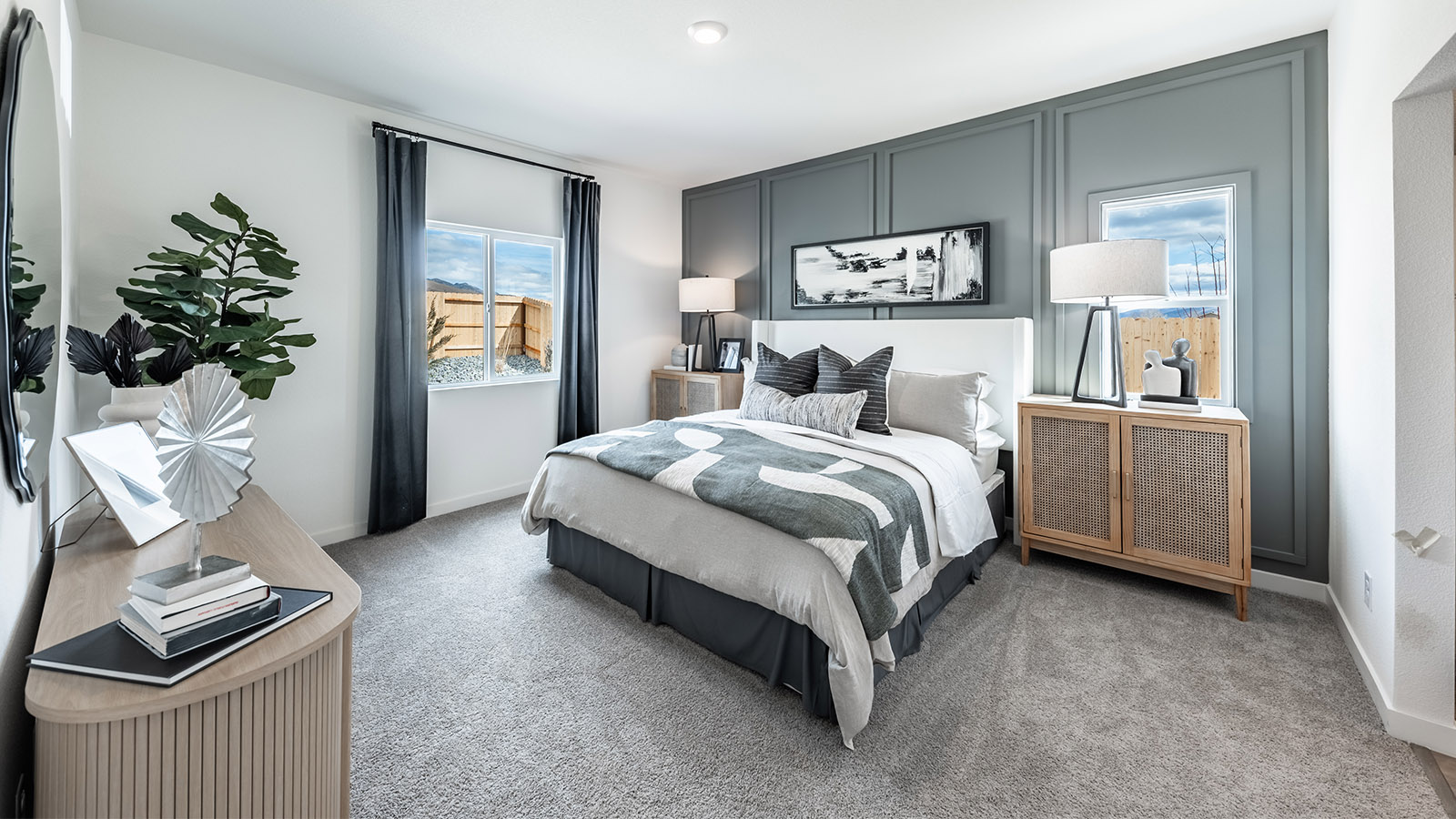 Spacious primary bedroom with two large windows and carpeted floor