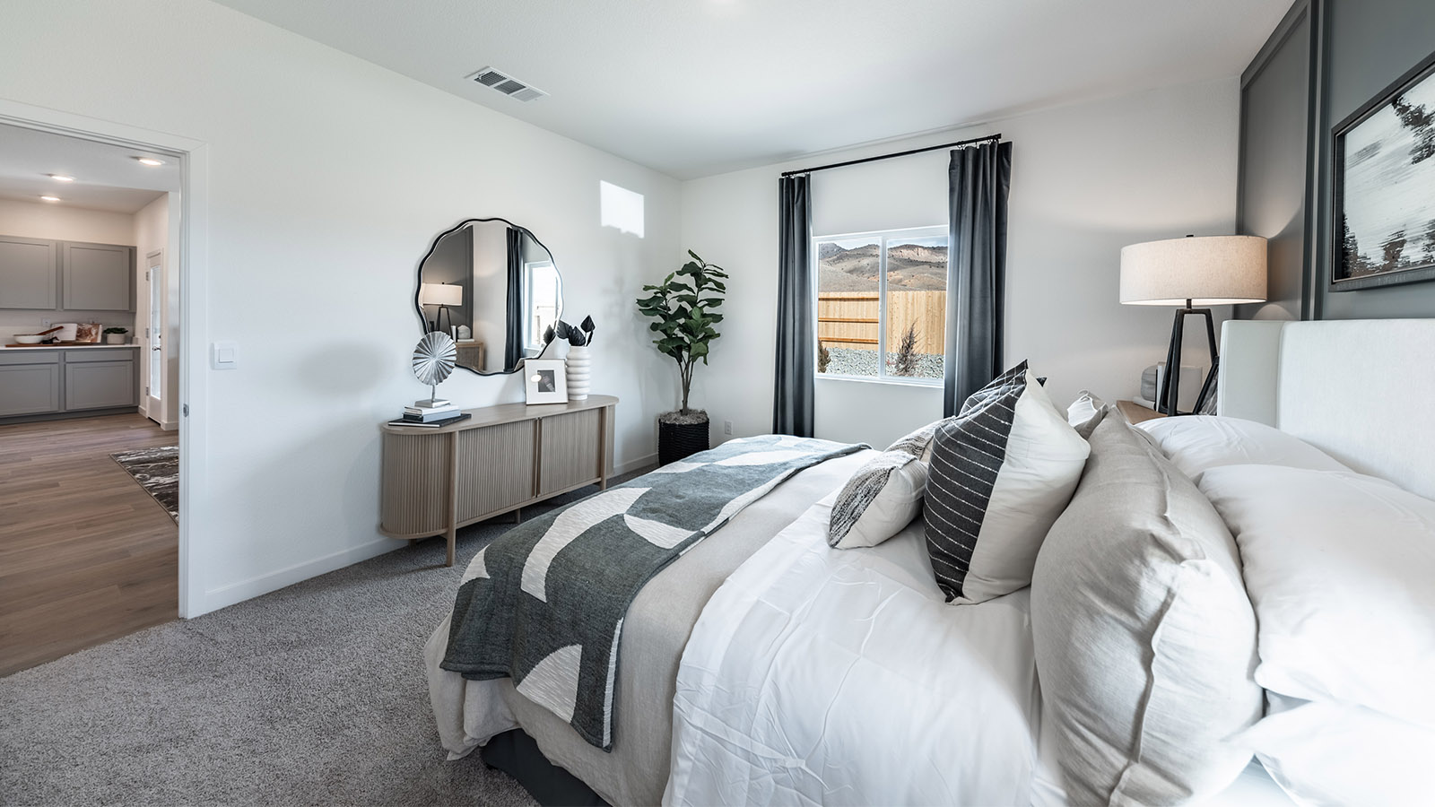 Primary bedroom with carpet next to living room