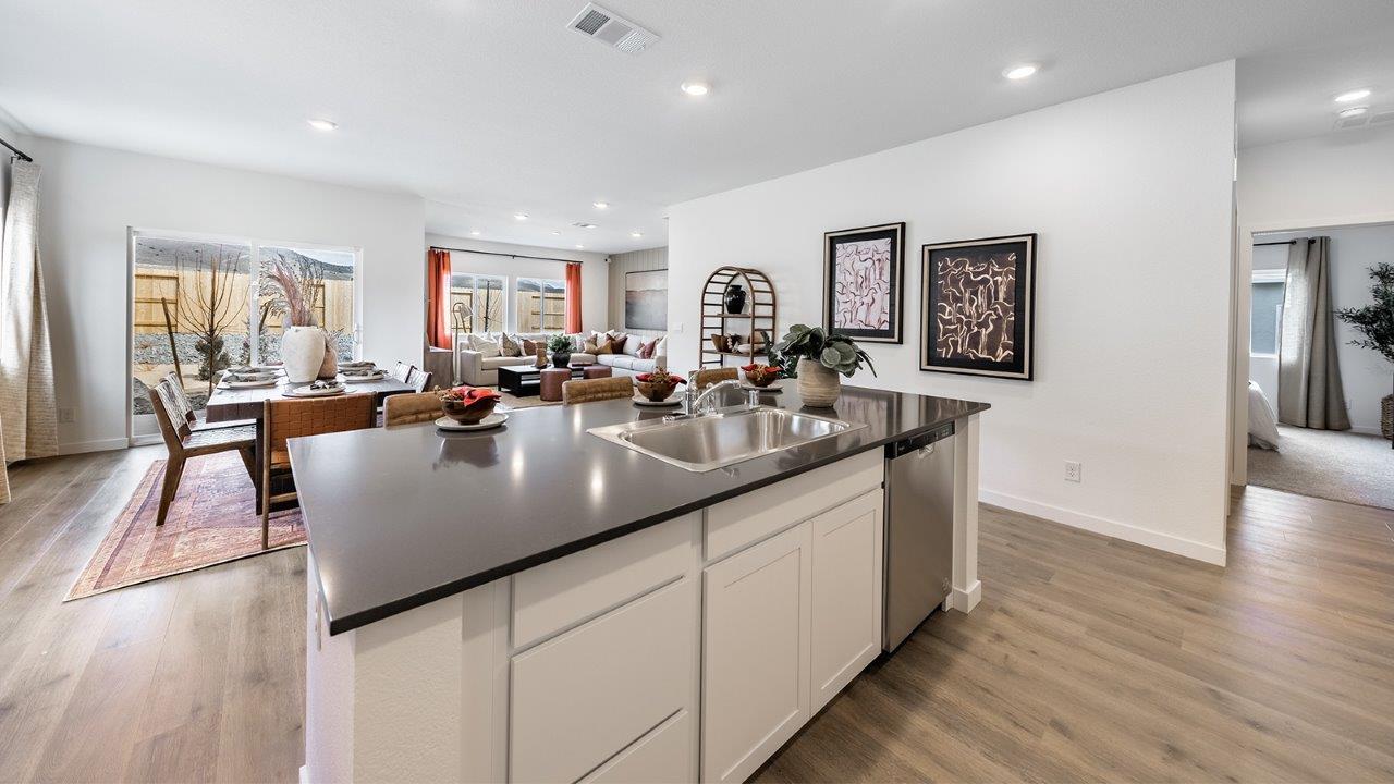 Spacious kitchen featuring an island with built-in dishwasher and sink