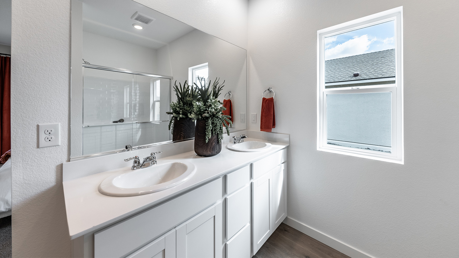 Primary bathroom double vanity next to small window