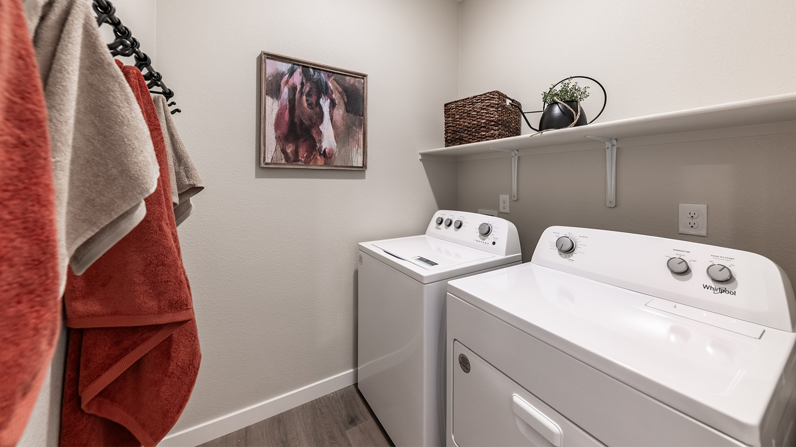 Laundry room with shelf above full-sized washer and dryer