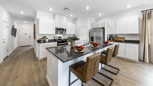 Kitchen with an island, white shaker-style cabinets and stainless steel appliances