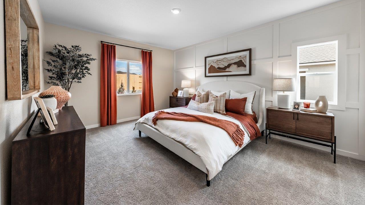 Carpeted primary bedroom with two large windows