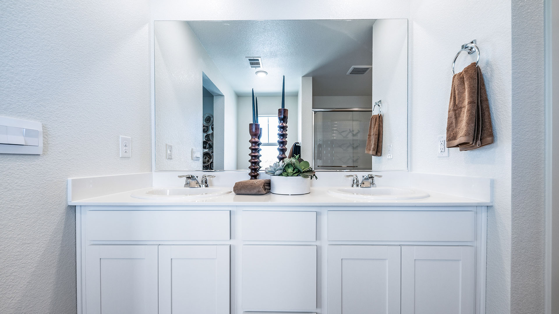 Double vanity in primary bathroom with built-in mirror