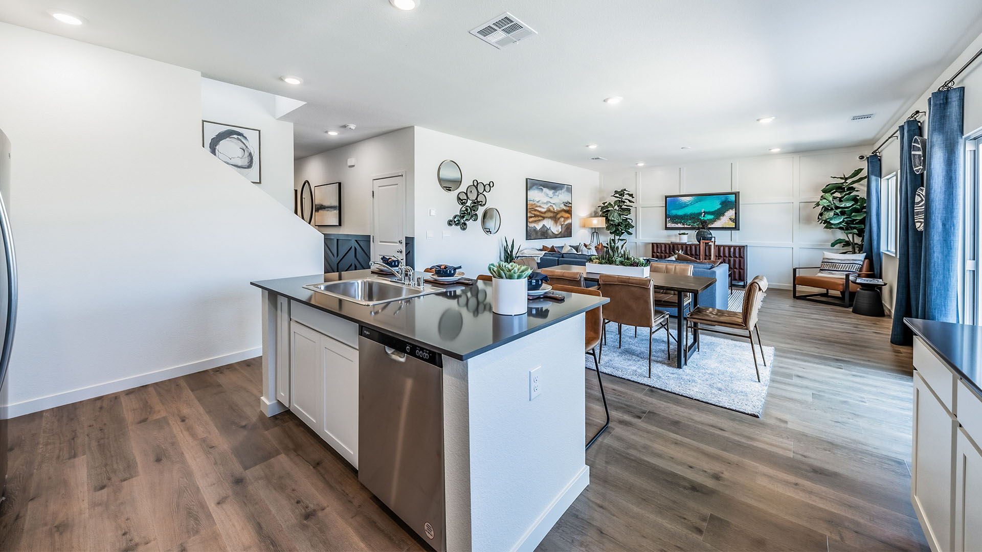 Kitchen island with built-in sink and dishwasher looking out onto dining and living area
