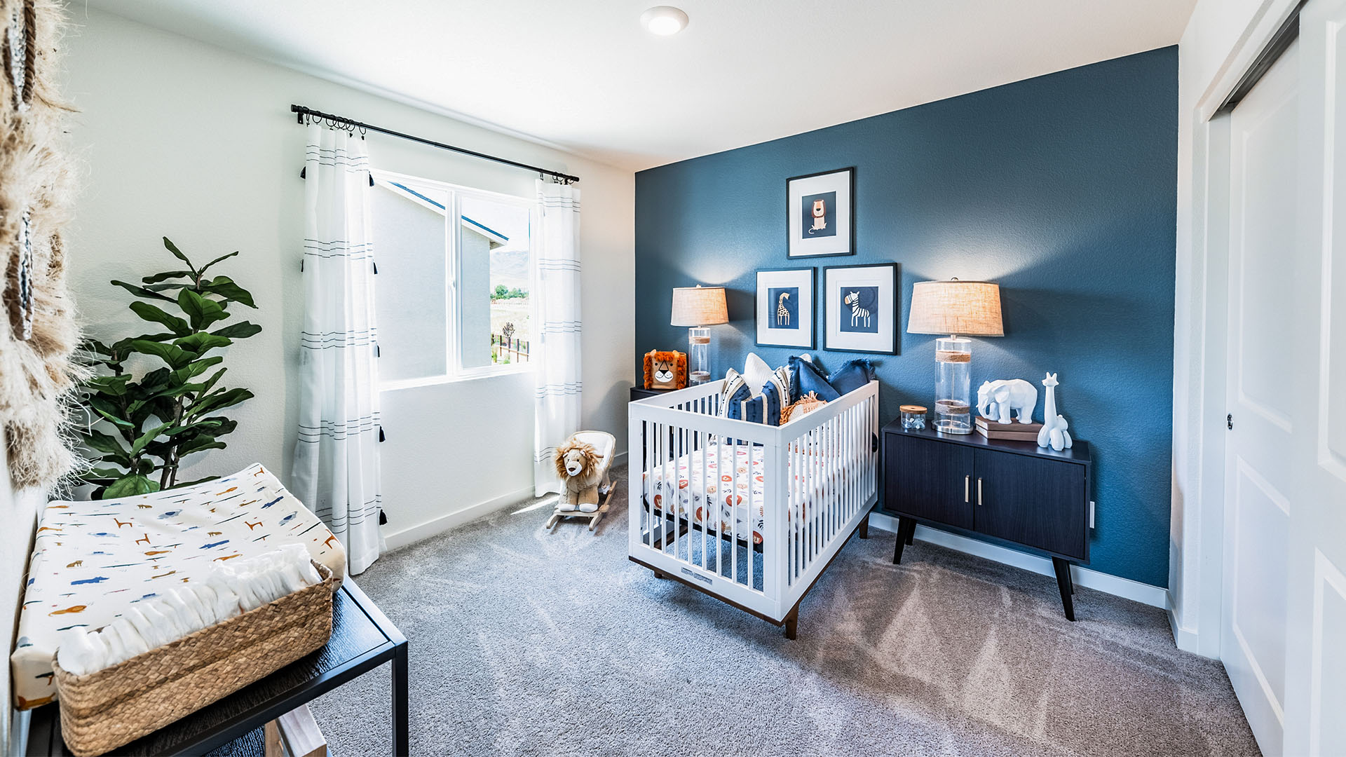 Nursery with carpet and large window letting in bright light