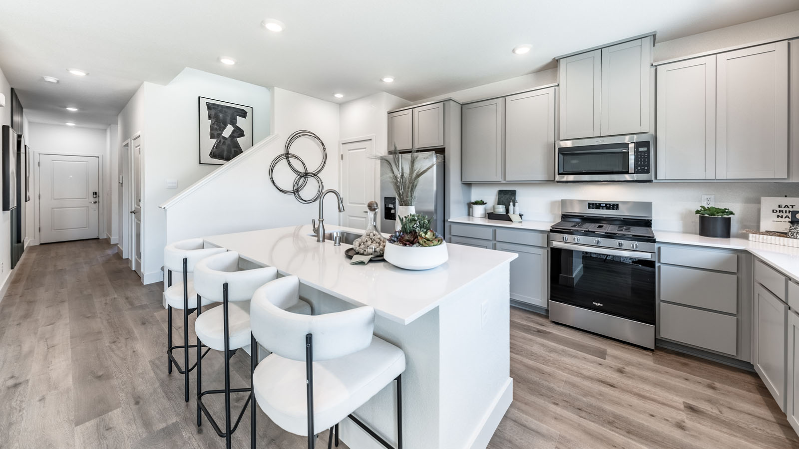 Open kitchen with shaker style cabinets and stainless steel appliances