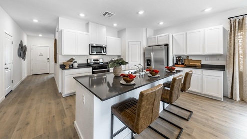 Kitchen island with dark countertops and white cabinets