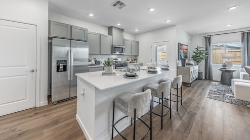 Kitchen with an island, grey shaker-style cabinets and light countertops