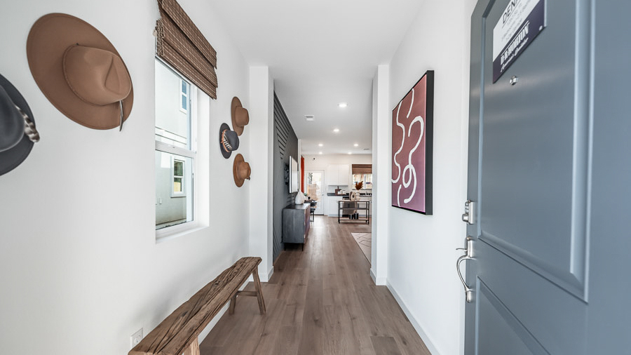 Front entryway of the Denali model home in Reno's Phoenix community with a long bench for seating and hats decorating the wall.