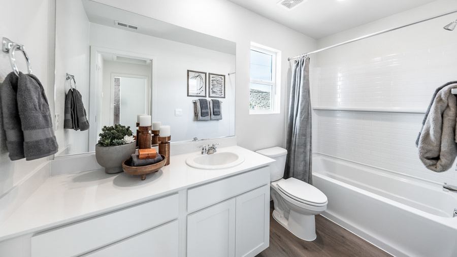 The Denali's secondary bathroom boasts white shaker cabinets, white countertops, a window to allow natural light, and a tub-shower combo.